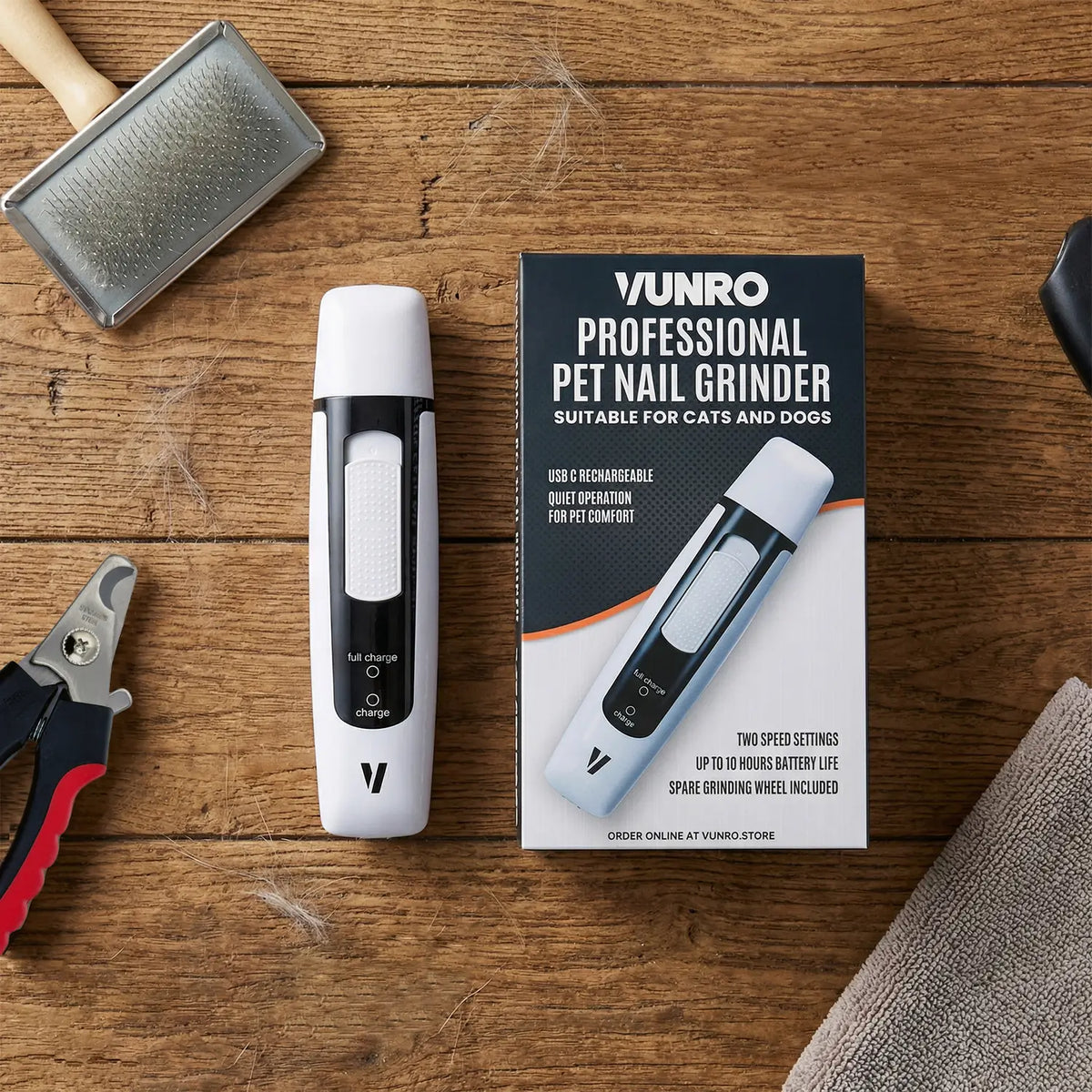VUNRO PRO Pet Nail Grinder beside its retail box with slicker brush and clippers on wood